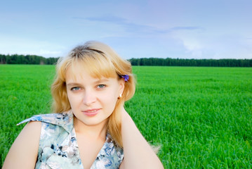 Fototapeta na wymiar Attractive smiling girl outside in green grass