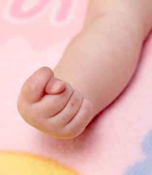 Hand of the child compressed in a fist on a diaper