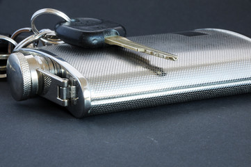 never drink and drive a car a key of a car with a alcohl bottle in silver