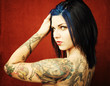Pretty young woman with many tattoos on her back and arms
