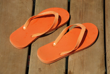 orange summer sandals on wood background