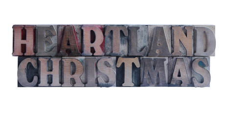 the words 'heartland Christmas' in old, ink-stained wood type
