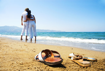 Young attractive couple at the beach (focused front view)