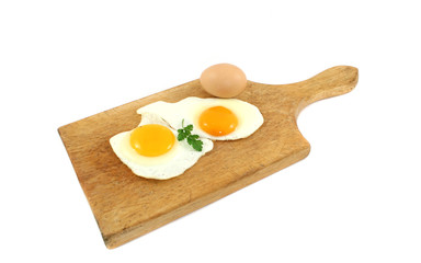 fried eggs on wooden board