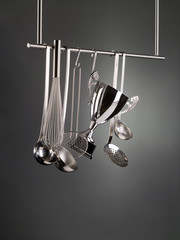 Cup trophy hanging among kitchen utensils on a rack