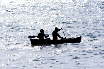 two men in a canoe on the open sea