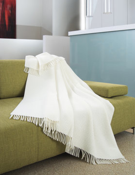 White Throw Draped Over A Settee