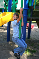 Boy sliding down the pipe in the park
