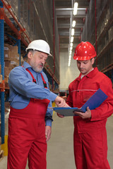 two workers in uniforms in warehouse