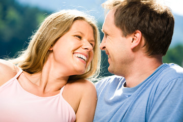 Joyful woman laughing while looking at smiling man