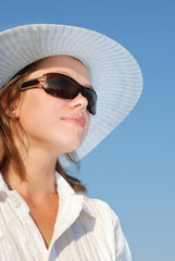 Fototapeta premium woman in sunglasses and a hat . The adult girl in white clothes