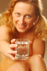 A blond young woman with glass of water