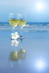 Reflection of two glasses of white wine on tropical beach