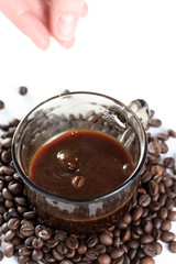 Cup with coffee, costing on coffee grain.