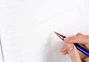 Close-up of woman hand writing in agenda