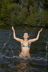 Young woman swimming in a river in the summer