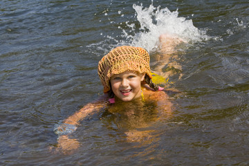 Little girl swimming in a river in the summer