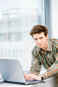 Casual looking businessman working on laptop computer