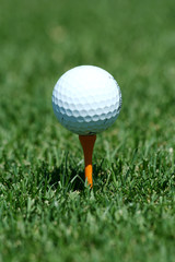A White golf ball on a orange tee