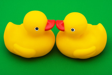 Two rubber ducks on green background, rubber ducks