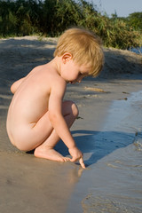 little boy play on the river bank