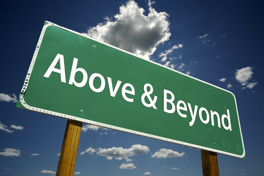 Above And Beyond Road Sign With Dramatic Clouds And Sky.