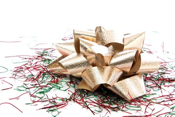 Pale gold foil bow sitting on red and green tinsel