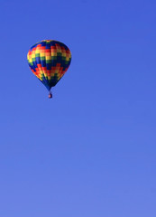Colorful hot air balloon in blue sky with plenty of copy space
