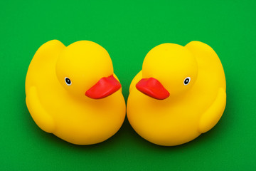 Two rubber ducks on green background, rubber ducks