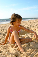 Fototapeta na wymiar fillette jouant sur la plage océane 3