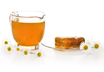 Jar with honey, honeycombs and camomiles