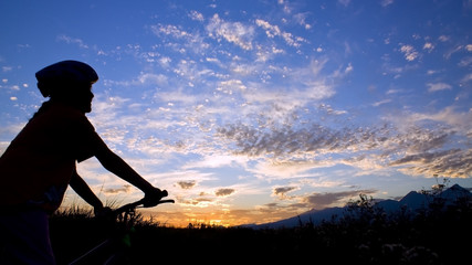 Biker girl silhouette in sunset