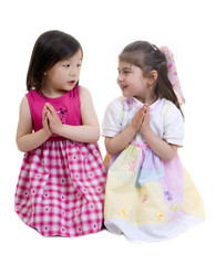 Two young girls kneeling and sharing a prayer