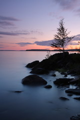 Fototapeta na wymiar Sunset by the lake, rocks, long exposure