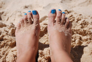 Female feet and sand on the beach