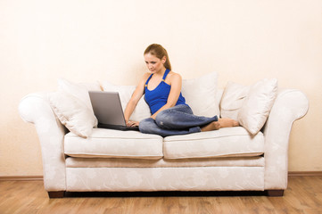 Plakat young woman on a lounge with laptop