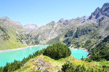 Fototapeta na wymiar A beautiful alpine lake with resort and vegetation