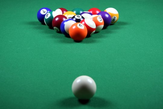 Colorful pool balls layed out on a table at the start of a game
