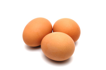 Three chicken eggs on a white background largly