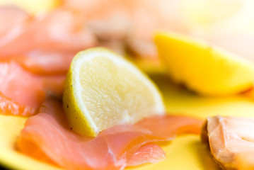 Fototapeta na wymiar salmon and lemon in yellow plate