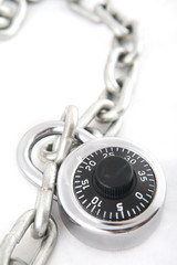 A combination lock an a silver chain shot with shallow DOF