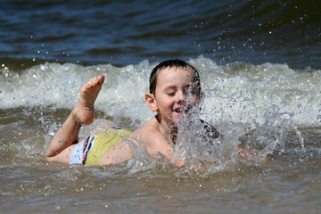 4 years old boy playing in the sea