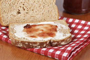 Toast and jam glass jar on square mat background. Shallow DOF