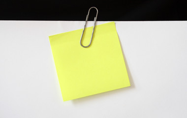 Yellow sticky note hanging with paper clip