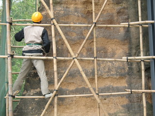 Construction worker standing on makeshift wooden stand