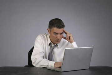 Businessman Contemplates with Computer