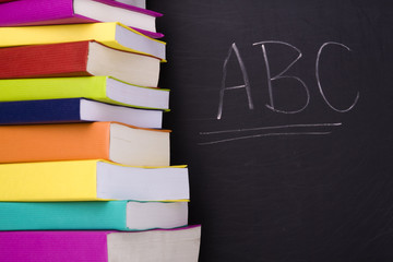 apple over a stack of books next to a chalkboard