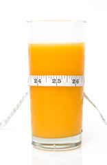 glass of tasty orange juice with measuring tape
