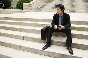 Businessman sitting on steps.