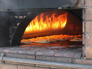 pizza prepares in old stove (oven) near fire
